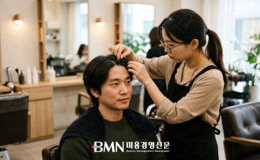 살롱 시술 의자에서 탈모 치료 중인 고객의 두피 상태를 세심하게 확인하는 헤어 디자이너