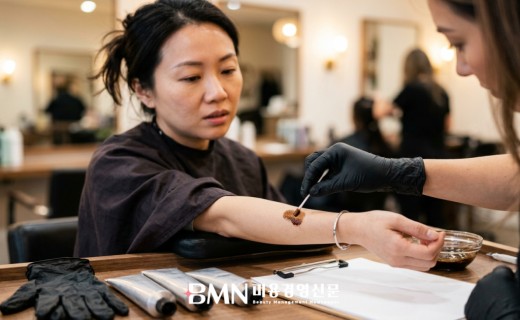 고객 팔 안쪽에 염모제 패치테스트를 진행하는 디자이너